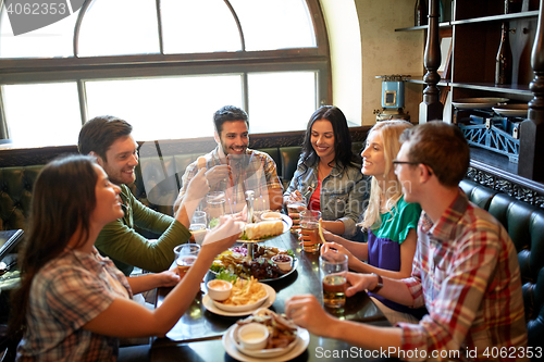 Image of friends dining and drinking beer at restaurant