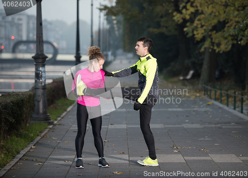 Image of couple warming up before jogging