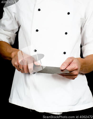 Image of Professional chef holding a sharp cooking knife in hands wearing