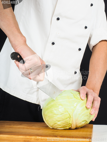 Image of Professional chef holding a sharp cooking knife onto a whole cab