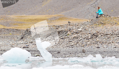 Image of Woman sitting on the beach at Jokulsarlon glacier lagoon - Icela