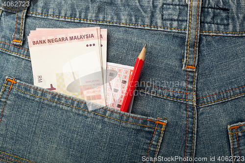 Image of Malaysian money and lottery bet slip in pocket