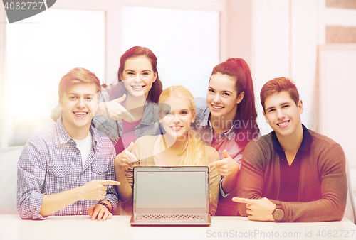 Image of smiling students pointing to blank lapotop screen