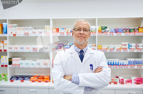 Image of senior male pharmacist in white coat at drugstore