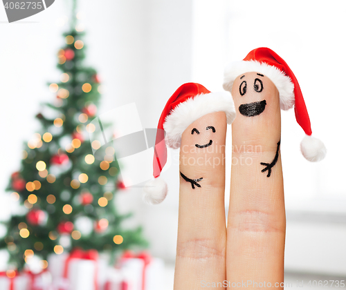 Image of close up of two fingers with smiley and santa hats