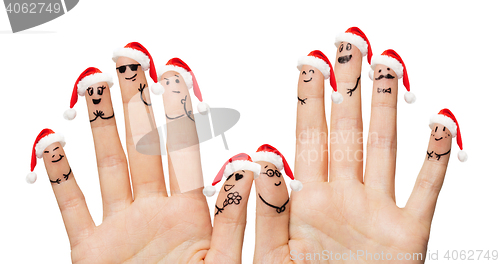 Image of close up of fingers with smiley in santa hats