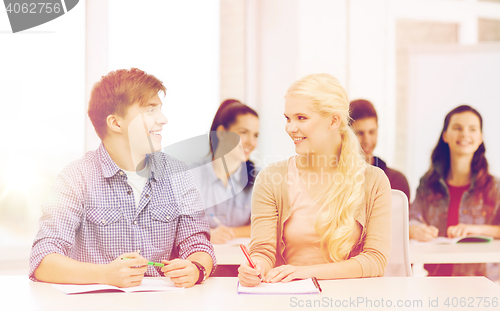 Image of two teenagers with notebooks at school