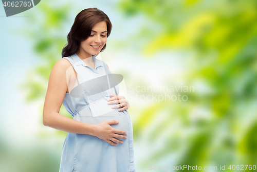 Image of happy pregnant woman touching her big belly