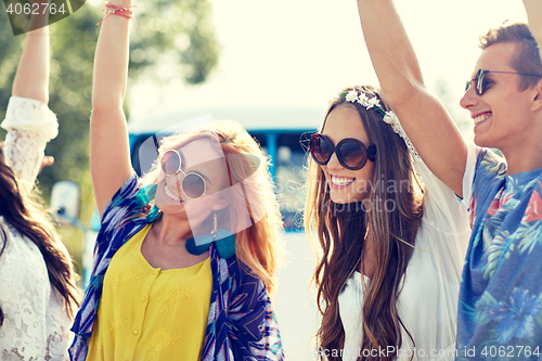 Image of happy young hippie friends dancing outdoors