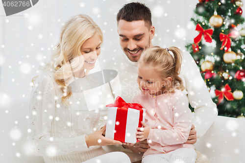Image of happy family at home with christmas gift box