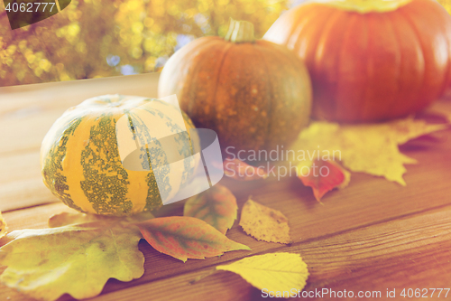 Image of close up of pumpkins on wooden table outdoors