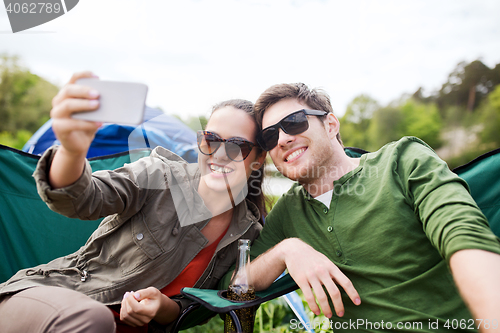 Image of couple of travelers taking selfie by smartphone