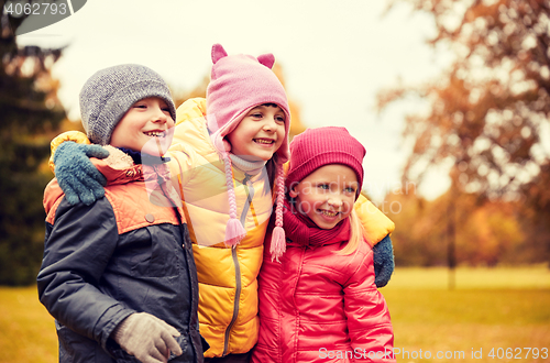 Image of group of happy children hugging in autumn park