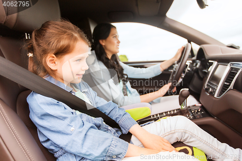 Image of happy woman with little child driving in car