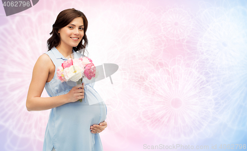 Image of happy pregnant woman with flowers touching belly