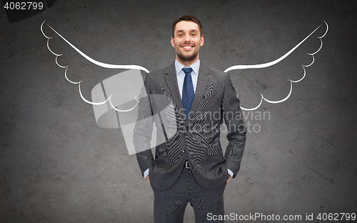 Image of happy businessman with angel wings over gray