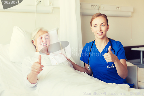 Image of nurse and senior woman showing thumbs up at clinic