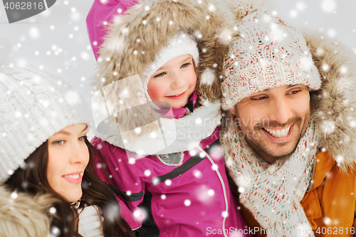 Image of happy family with child in winter clothes outdoors