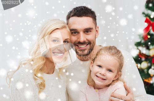 Image of happy family at home with christmas tree