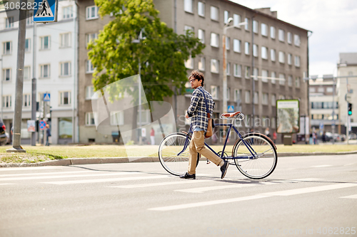 Image of young man with fixed gear bicycle on crosswalk