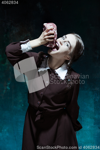 Image of Bloody Halloween theme: crazy girl with raw meat