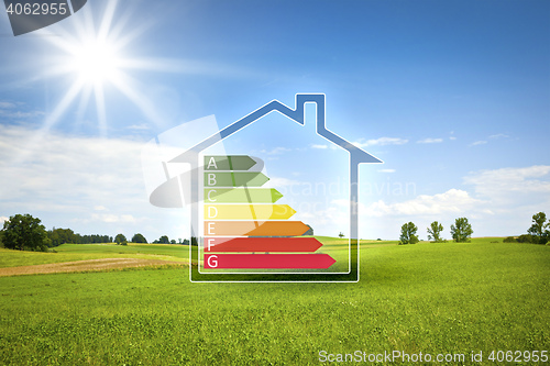 Image of green house in the sun with energy efficiency graph