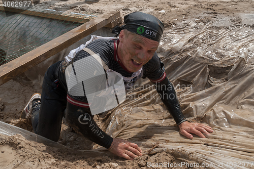 Image of Man creeps on an entrenchment with sand and water