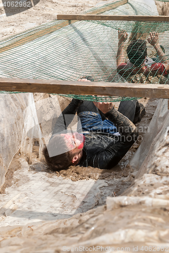 Image of Men creep on an entrenchment with sand and water