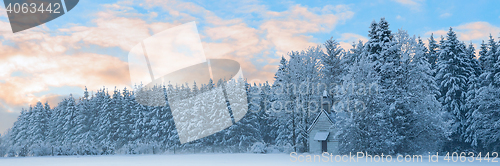 Image of Panoramic landscape of snowbound forest with frosty small church