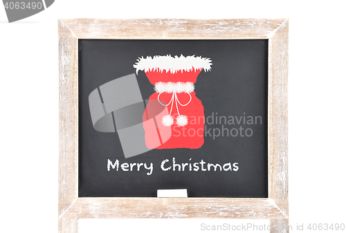 Image of Christmas greetings with Santas bag on blackboard