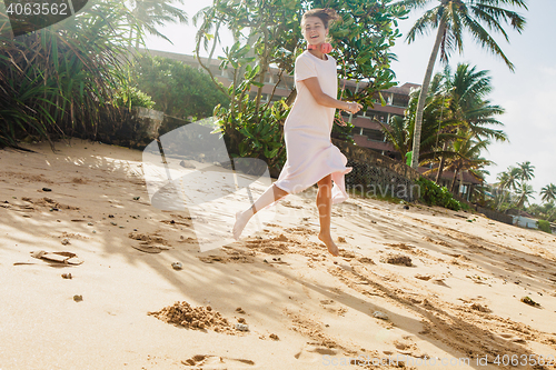 Image of Woman walking on the beach sand