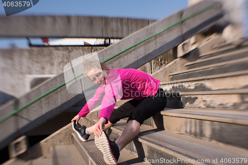 Image of woman  stretching before morning jogging