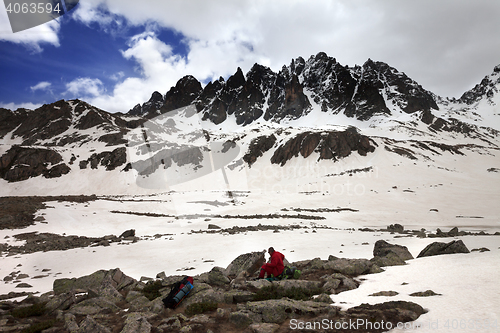 Image of Hiker with dog resting on halt in snow mountain at gray day