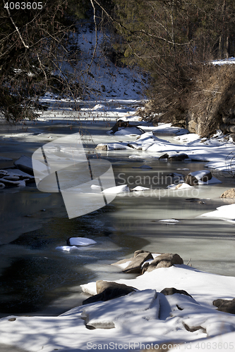 Image of Frozen mountain river in sun winter morning