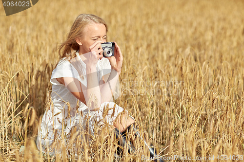 Image of woman taking picture with camera in cereal field