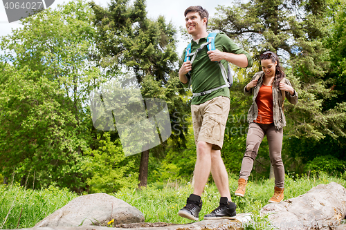 Image of happy couple with backpacks hiking outdoors