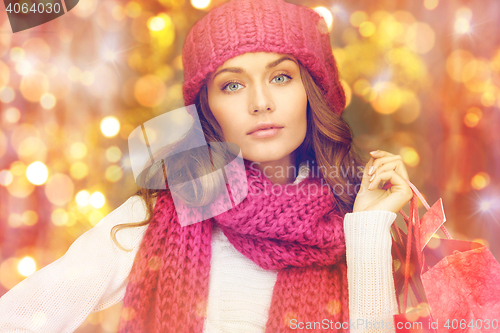 Image of happy woman in winter clothes with shopping bags
