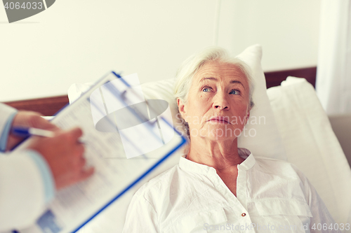 Image of doctor visiting senior woman patient at hospital