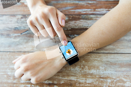 Image of close up of hands with music player on smart watch