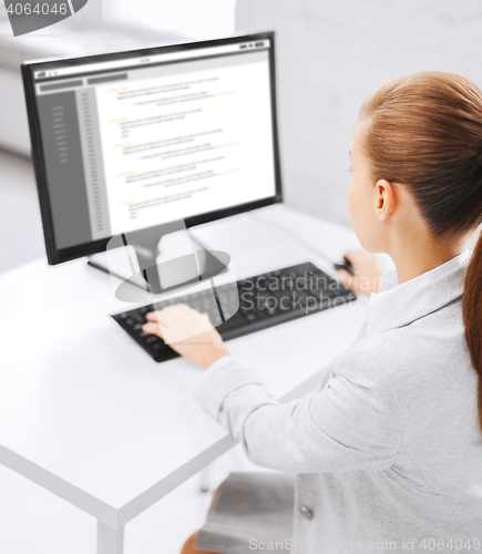 Image of businesswoman with coding on computer at office