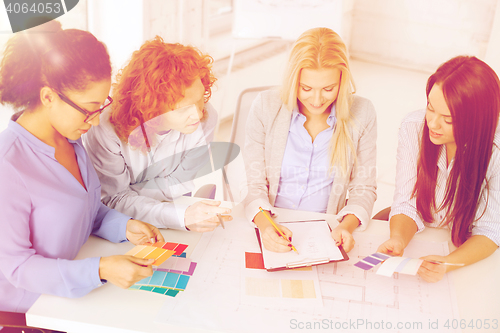 Image of team with color samples and blueprint at office