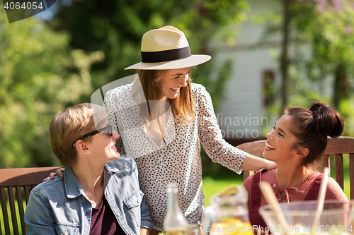 Image of happy friends having dinner at summer garden party