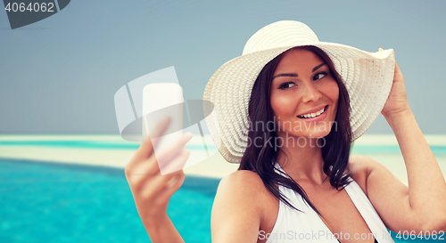 Image of young woman taking selfie with smartphone