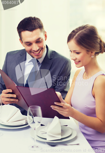 Image of smiling couple with menu at restaurant