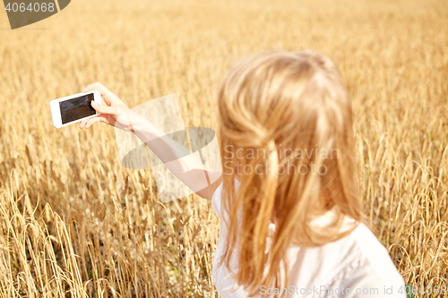 Image of close up of girl with smartphone on cereal field