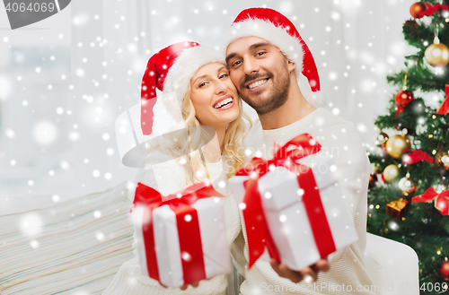 Image of happy couple at home with christmas gift boxes