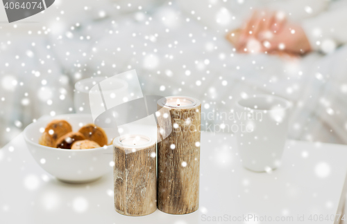 Image of close up of candles, cookies and tea cups on table