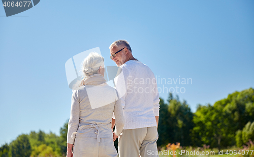 Image of happy senior couple walking outdoors