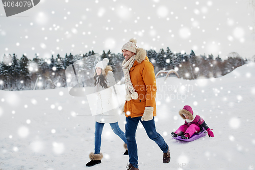 Image of happy family with sled walking in winter outdoors