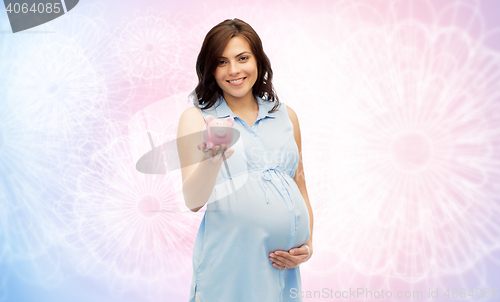 Image of happy pregnant woman with piggybank